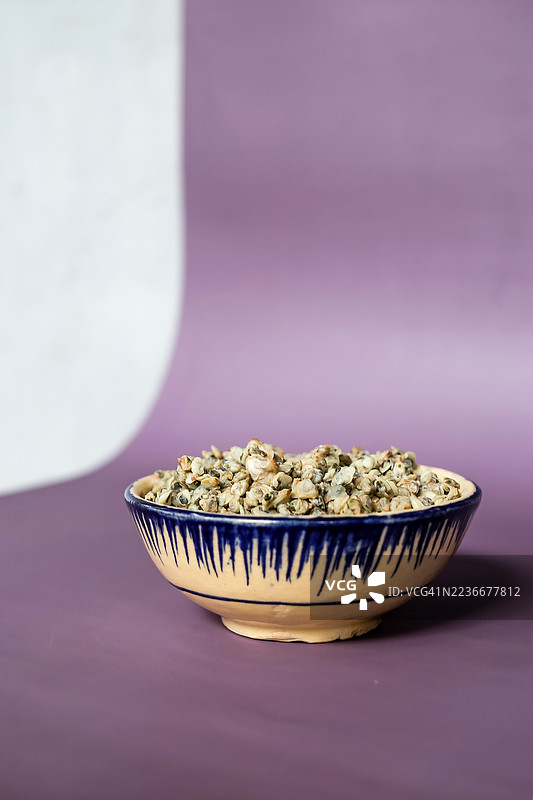 一碗煮熟的小蛤蜊，背景为紫色图片素材