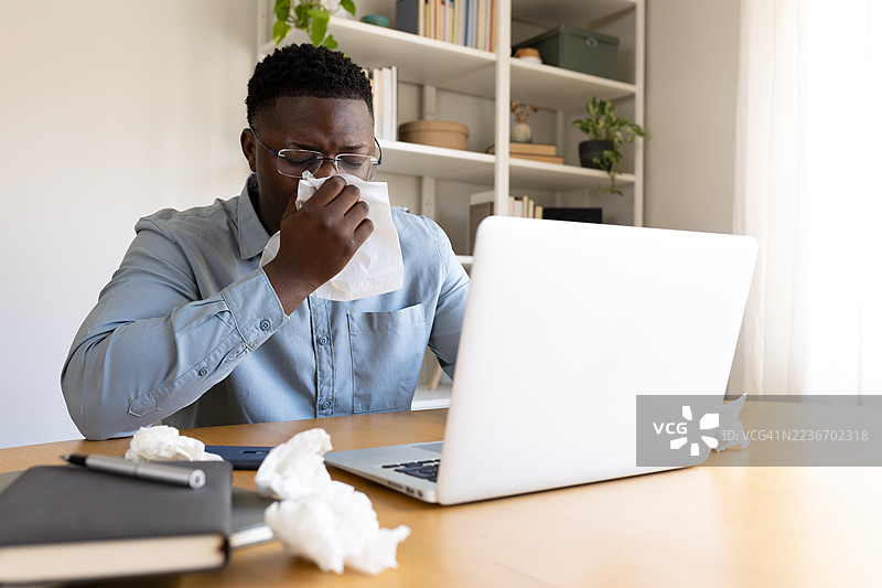 在家工作时，黑人男性正在擤鼻子图片素材