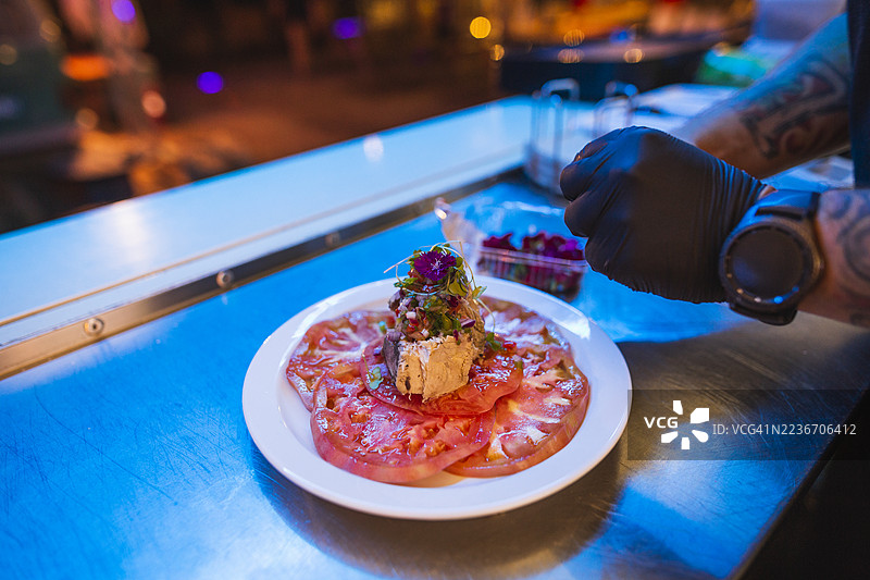 厨师的手在餐车里准备番茄沙拉图片素材