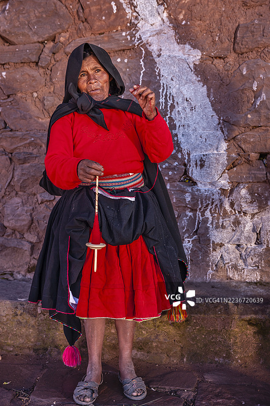 在秘鲁塔基莱岛上，女人用手纺羊毛图片素材