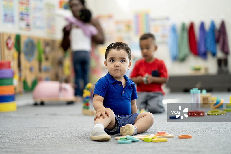 幼儿园课堂上多元化儿童学习颜色和形状的游戏场景图片素材