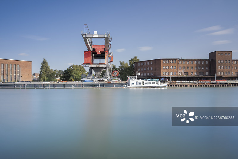 从米特兰运河远眺工业建筑和船前起重机，长时间曝光，加布森，汉诺威，下萨克森，德国图片素材