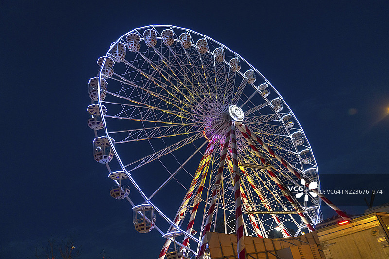 在法国巴约讷，摩天轮在圣诞节庆祝活动中照亮夜空，营造出节日和魔幻的氛围。图片素材
