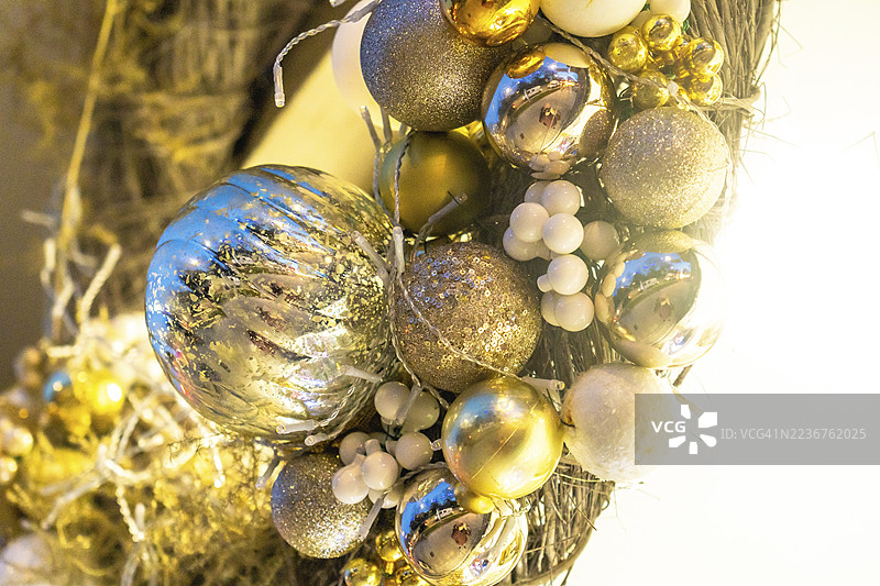 特写的圣诞花环，装饰着金银闪亮的饰品和白色浆果，为法国巴约讷的节日季节增添了节日气息。图片素材