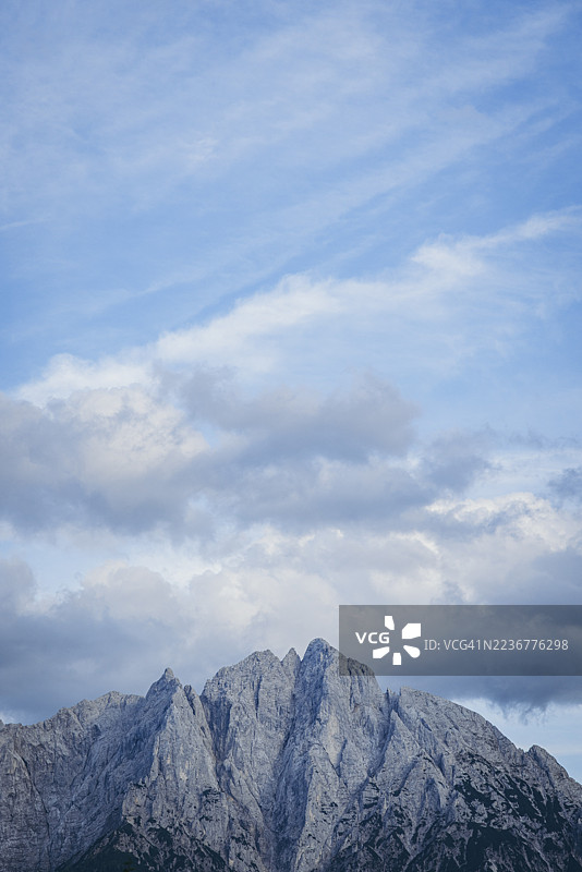 奥地利施蒂利亚州盖萨乌斯的云雾蓝天下，巍峨的厄德斯坦山峰图片素材