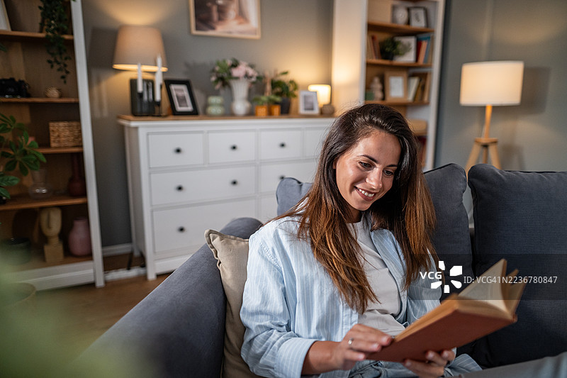 年轻女性在家中放松阅读书籍图片素材