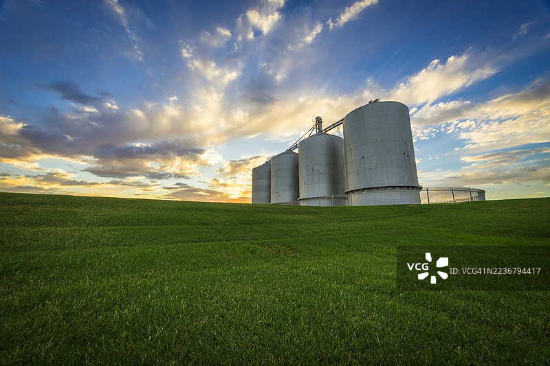美国吉尔伯特，S. Kennith Lane，绿色草坡上的谷仓，戏剧性的日落天空图片素材