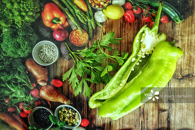 木桌上新鲜蔬菜和香草的俯视特写，准备烹饪图片素材