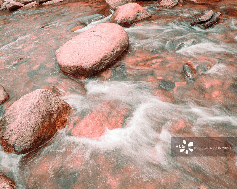 高角度视图，河水流过岩石，采用长时间曝光以获得平滑效果图片素材