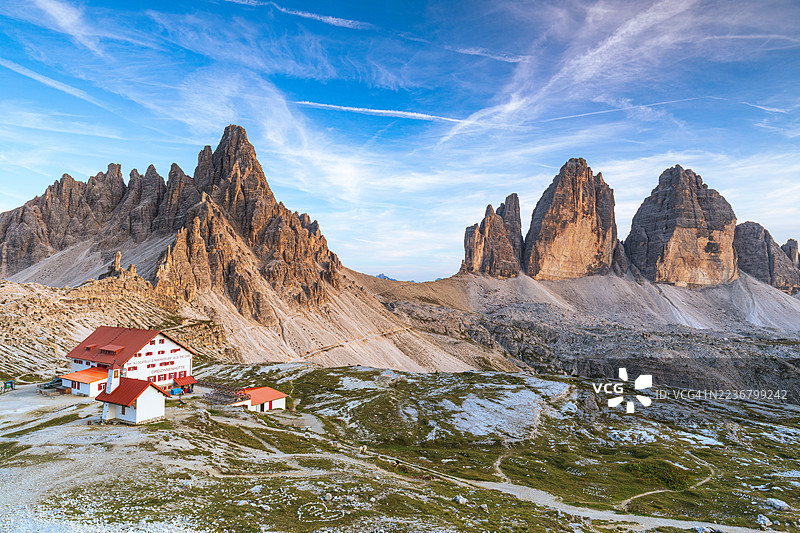 意大利多洛米蒂山脉下，蓝天映衬下的壮丽特雷奇梅山脉全景及一座山间小屋，位于多比亚科。图片素材