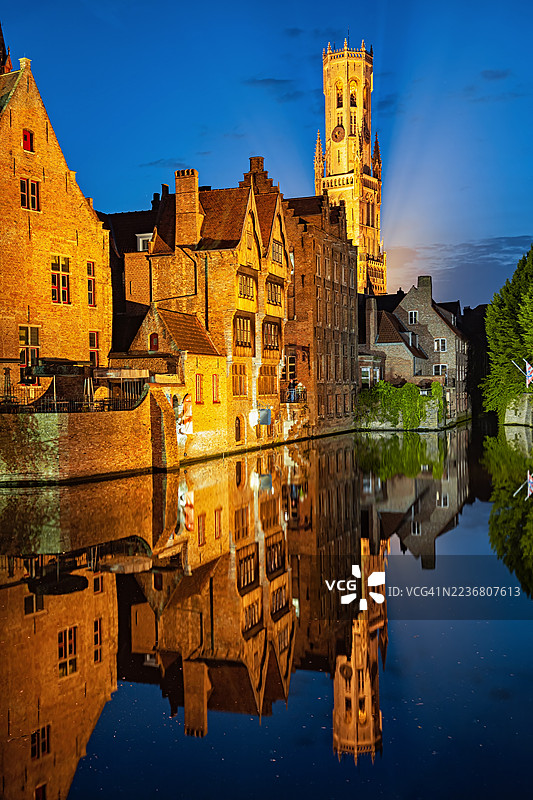 布鲁日的历史建筑和钟楼在黄昏时分倒映在运河中图片素材