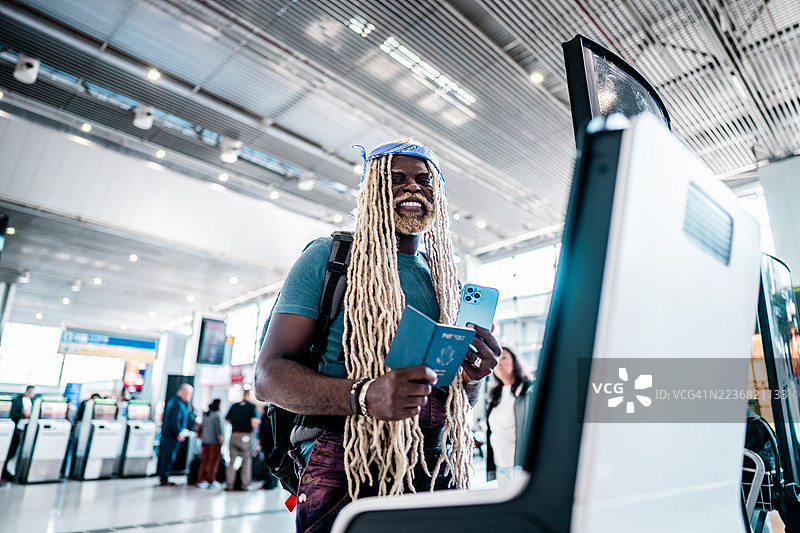 中年男子在机场使用自助值机机的肖像图片素材