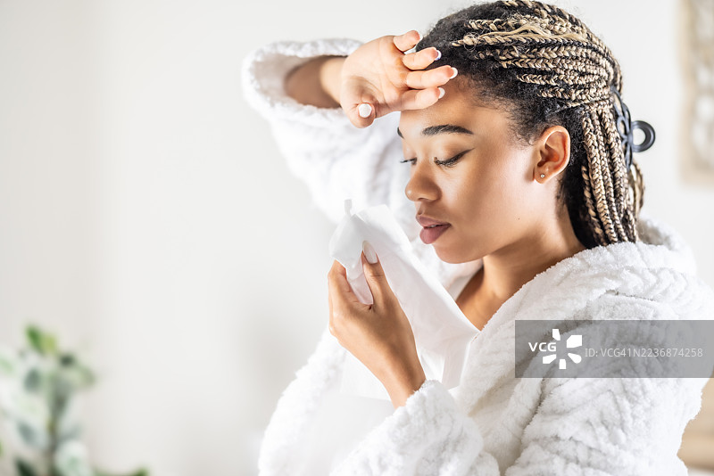 生病或疲惫的年轻女性用纸巾擦鼻子图片素材