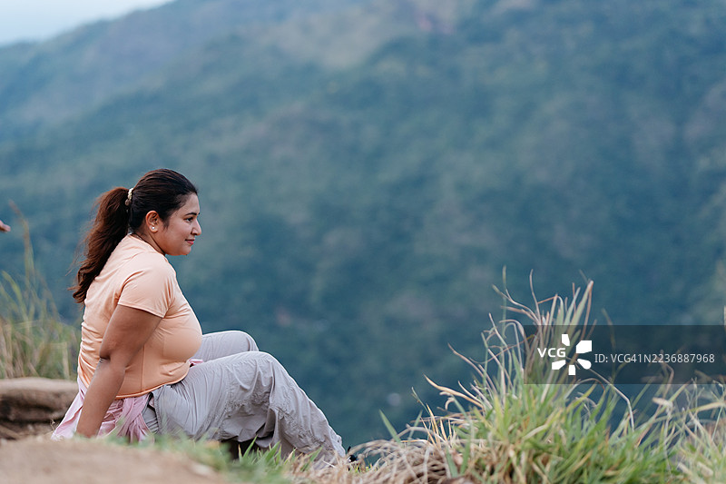 年轻的印度女性在亚当峰顶享受风景图片素材