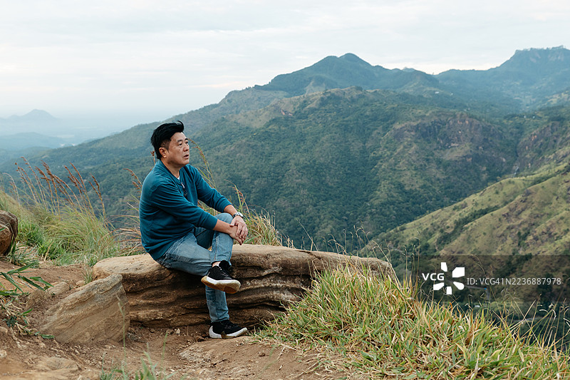 一位成熟的亚洲男子在亚当峰小顶上欣赏风景图片素材