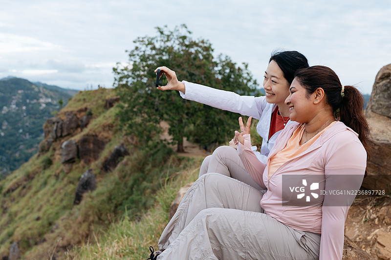 亚洲女性在斯里兰卡小亚当峰顶欣赏风景图片素材