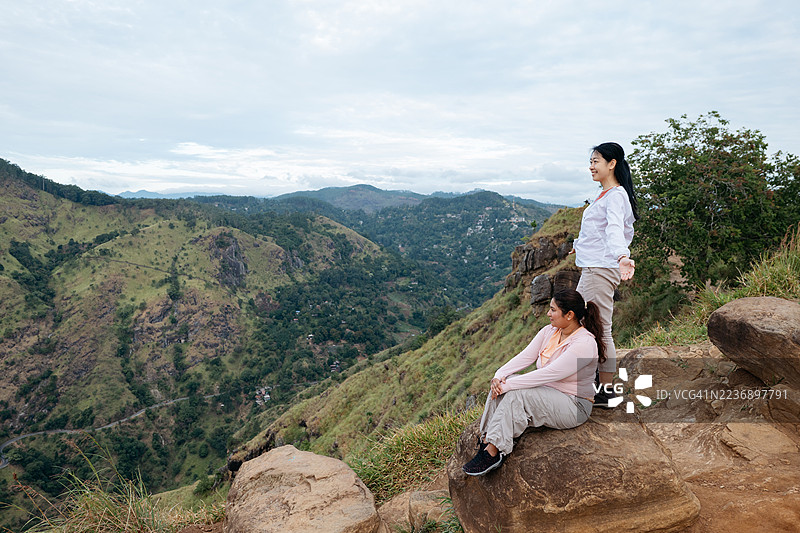 亚洲女性在斯里兰卡小亚当峰顶欣赏风景图片素材