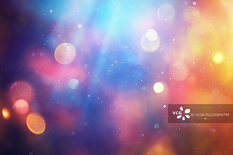 温暖的金色和蓝色散景灯光在渐变背景上创造出神奇的氛围，柔和的光圈和闪烁的粒子交织在一起。图片素材