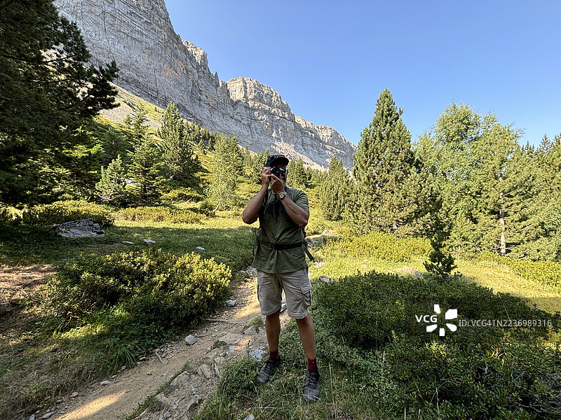男子在森林小径上拍摄自然风光图片素材
