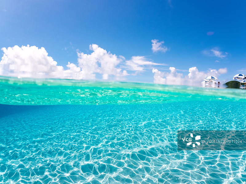 可以看到阳伞、船只，甚至一种独特于冲绳的双体船——萨巴尼。拍摄了美丽的白沙滩的一半。还有一群热带鱼。美丽的珊瑚礁和游泳的人们。外岛，座间味岛，慶良間群岛。图片素材