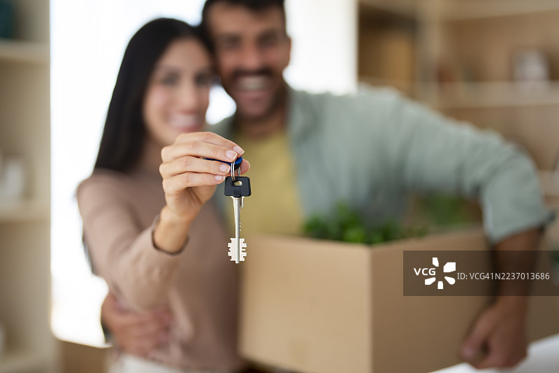 快乐的情侣手握新房钥匙：庆祝新家拥有权图片素材