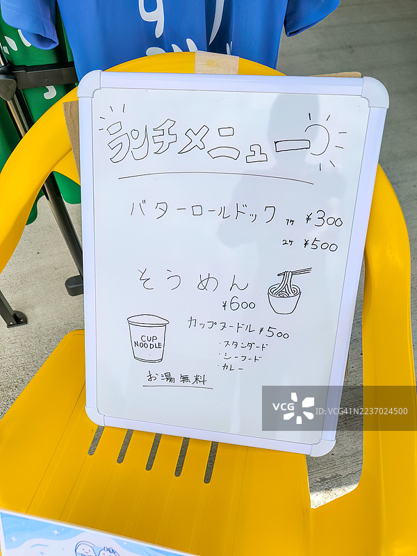 手写的午餐菜单。海滨小屋午餐：素面、瓶装啤酒和小热狗。日本静冈县伊豆半岛南伊豆町入间海滩、中木港。- 2025年7月21日。图片素材