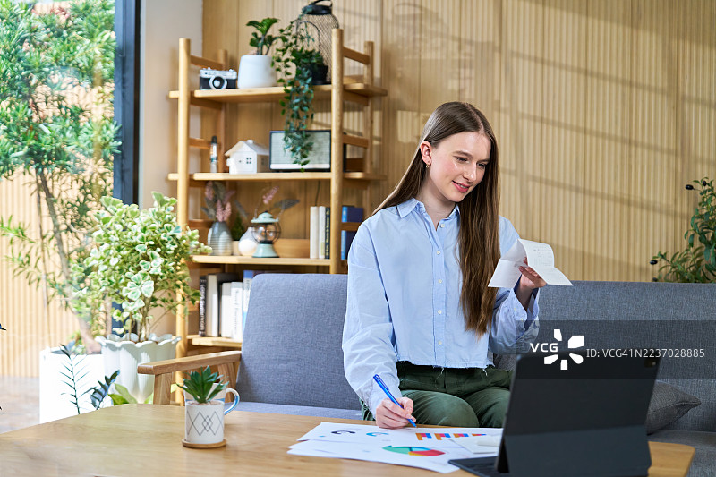 年轻女性在家工作时计算开支图片素材