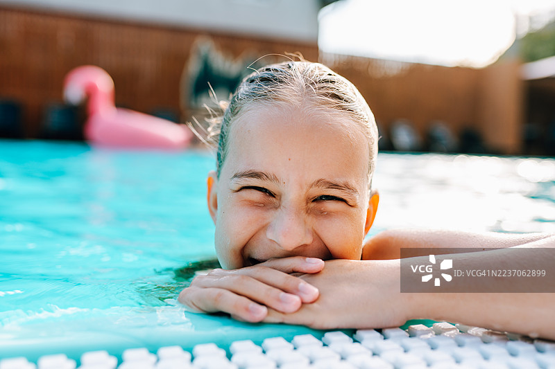快乐的少女在夏日泳池中大笑图片素材