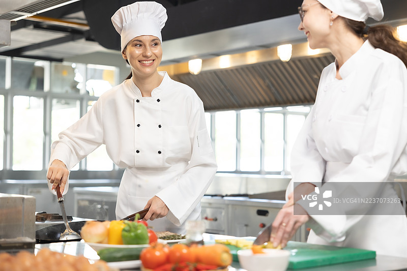 女厨师在烹饪课堂上协助并讲解一些技巧和窍门图片素材