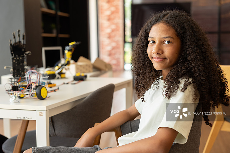 聚焦机器人手臂，孩子们在老师的指导下进行动手STEM活动。多种族学生在机器人课程中与机器人车辆一起学习。图片素材