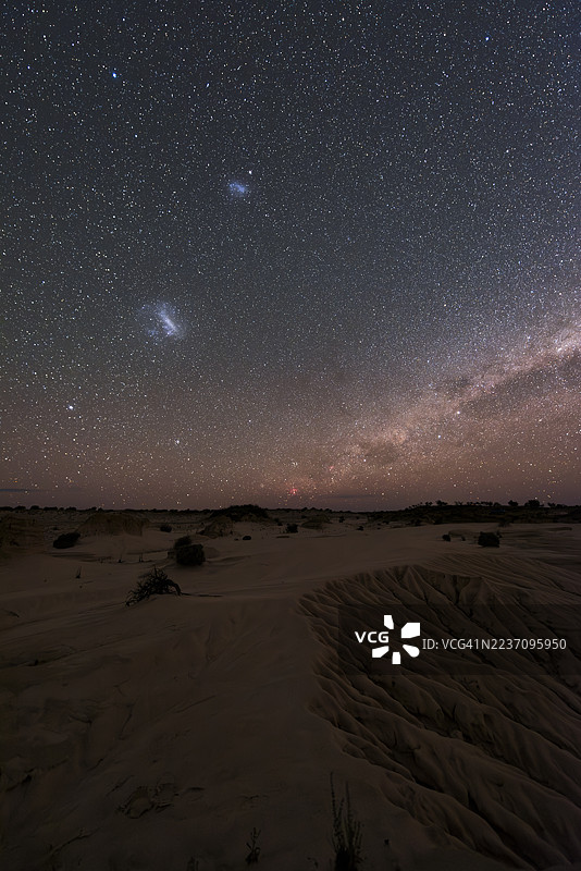 马格兰云和南方银河在地平线上：拍摄于澳大利亚新南威尔士州的芒戈国家公园（卡里纳座大星云、跑鸡星云和南十字星就在地平线上方）图片素材