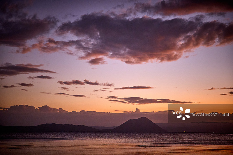 塔尔湖上宁静的日落，塔尔火山的轮廓在地平线上显现。图片素材