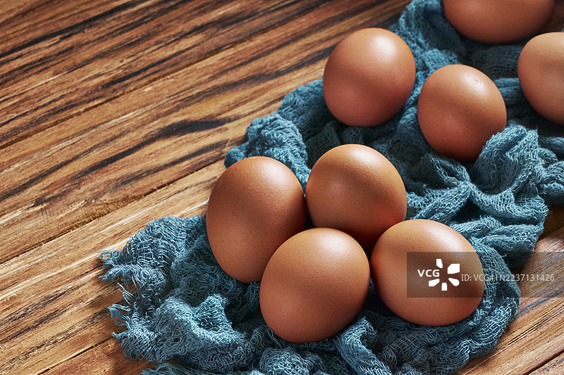 在乡村风格的木桌上放着棕色鸡蛋。图片素材
