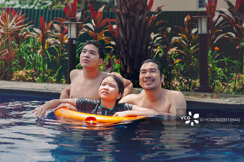 父亲与两个十几岁的孩子在泳池中增进感情图片素材