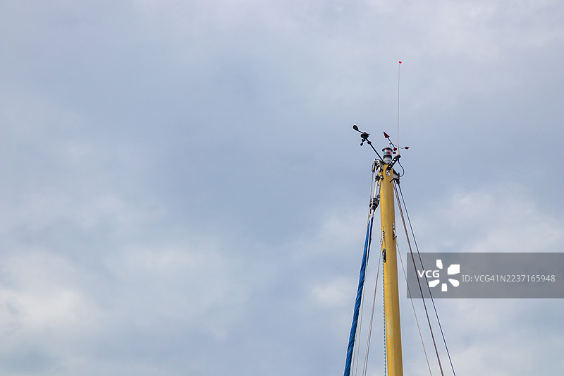 低角度拍摄的帆船桅杆，包括索具和仪器，背景为多云的天空，芬兰图片素材
