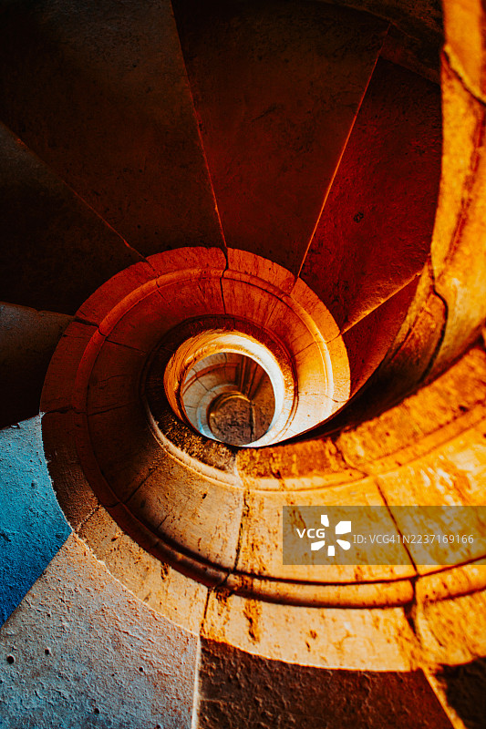 葡萄牙托马尔的螺旋楼梯俯视特写，暖色灯光图片素材