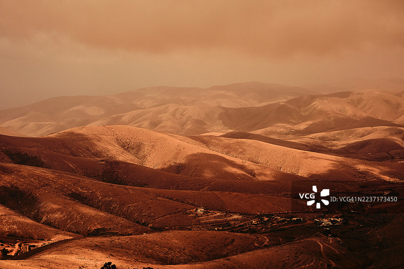 戏剧性的沙漠景观，起伏的山丘在阴天之下，唤起一种广阔和孤独的感觉，西班牙贝坦库里亚图片素材