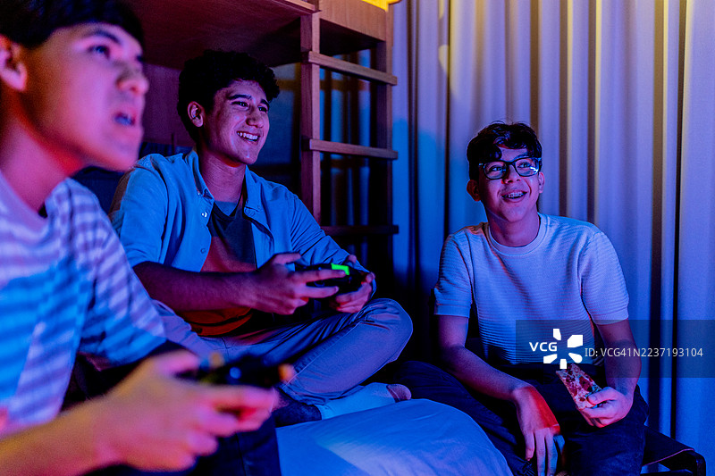 家里的少年们在玩电子游戏图片素材