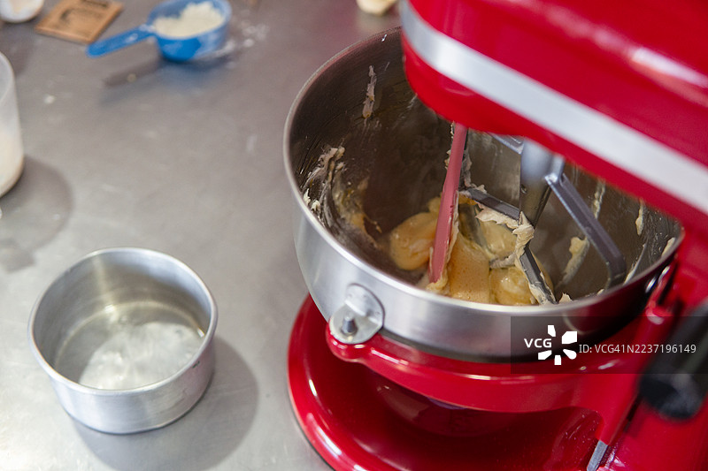 厨房里，红色的立式搅拌机正在准备制作糕点面团。图片素材