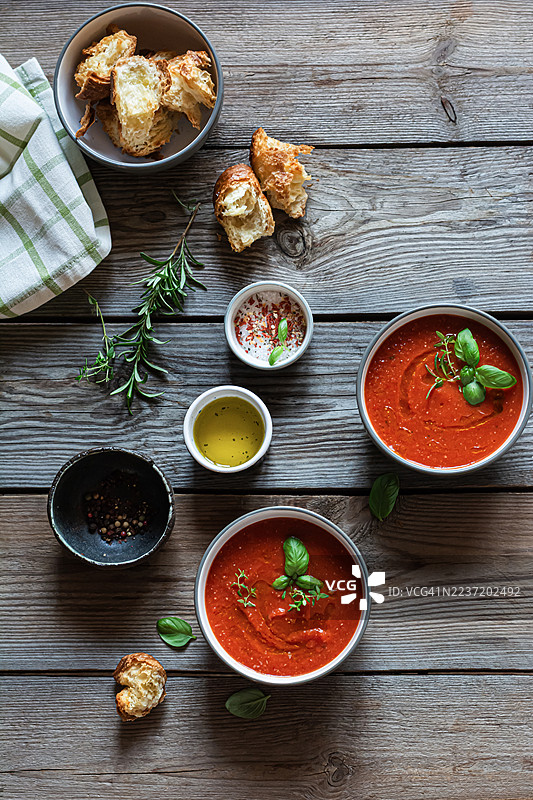 自制番茄汤泥，配以香草、橄榄油和烤面包丁，背景为木质桌面。轻盈的晚餐。图片素材