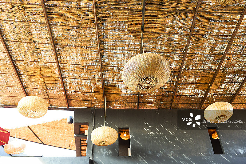 悬挂在竹天花板上的编织灯具图片素材