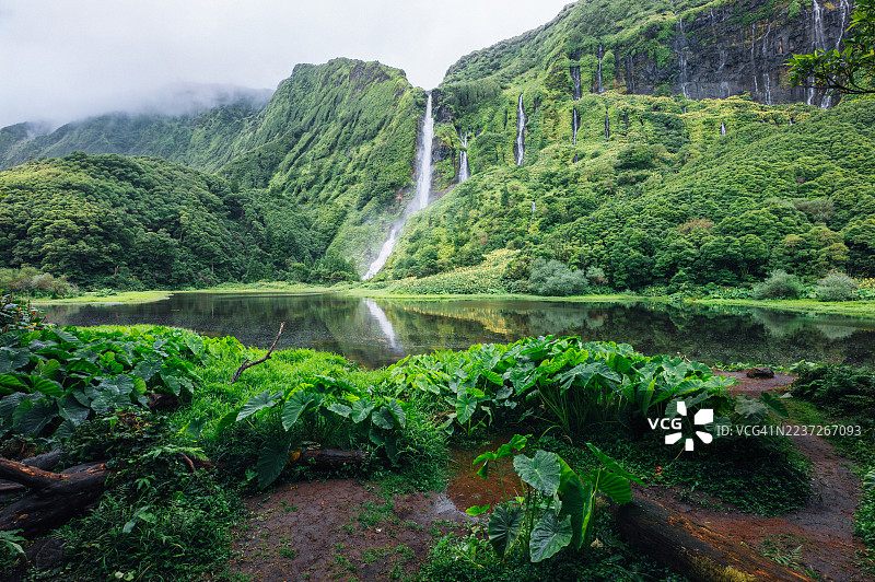 郁郁葱葱的山坡上有多条瀑布倾泻而下，汇入宁静的湖泊。图片素材