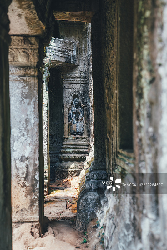 柬埔寨暹粒省暹粒吴哥窟的古代寺庙走廊和石雕佛像图片素材