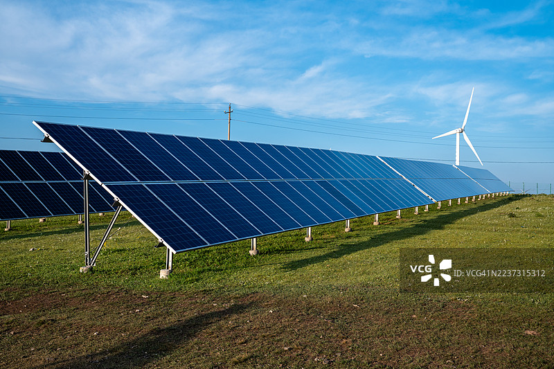 草原上的太阳能电池板和风力涡轮机图片素材