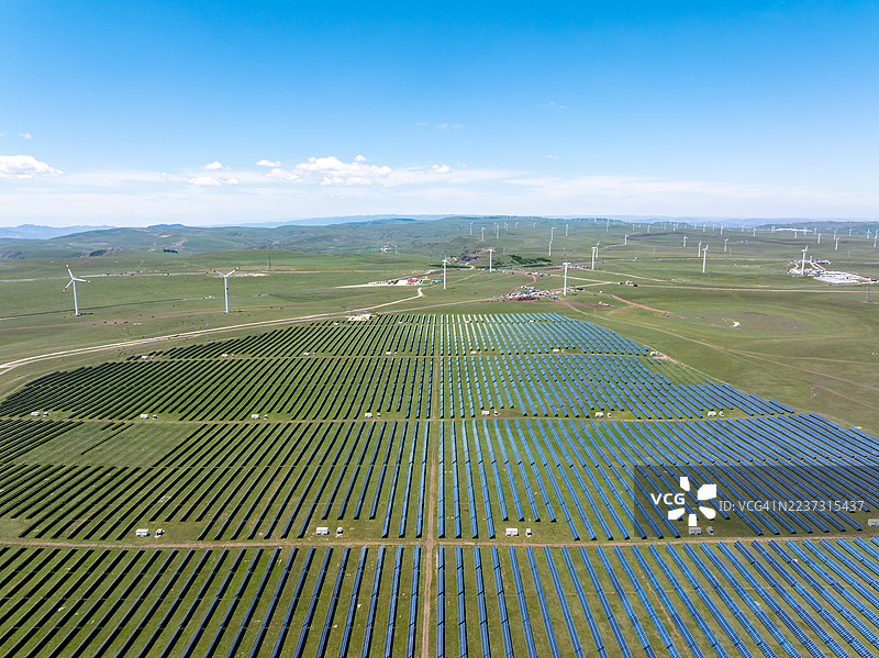 草原上的太阳能电池板和风力涡轮机图片素材