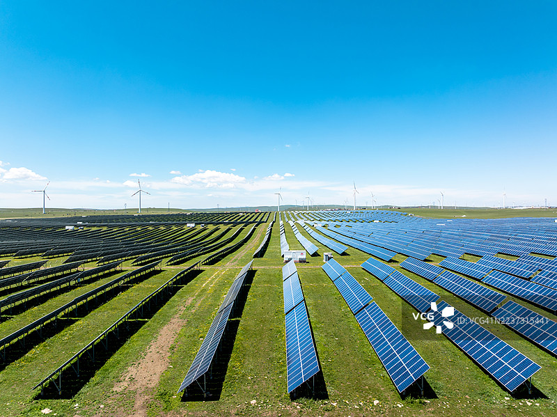 草原上的太阳能电池板和风力涡轮机图片素材