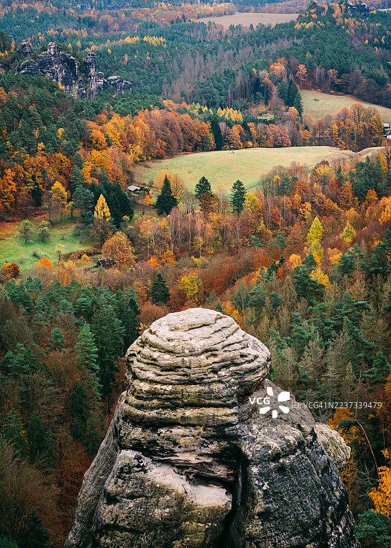 德国萨克森瑞士国家公园埃尔贝 sandstone 山脉中的秋季森林俯瞰，岩石形成与色彩斑斓的树叶夹在悬崖之间。图片素材