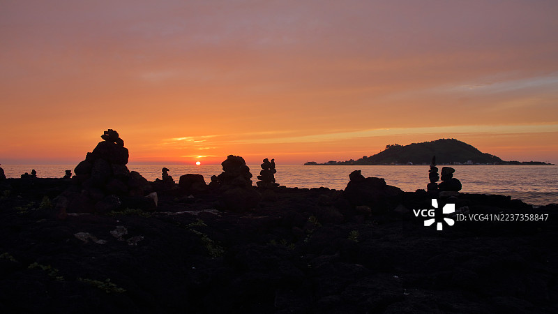 从济州岛的协才海滩俯瞰比阳岛的日落图片素材