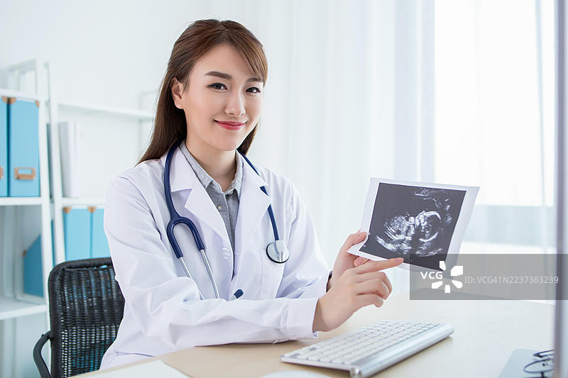 女医生在医疗办公室里拿着超声波图像图片素材