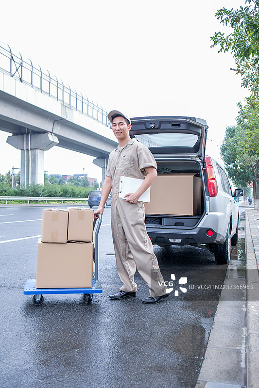 送货员在路上与箱子和车辆图片素材